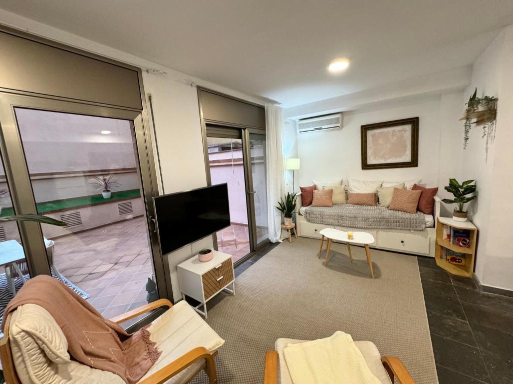 ピネダ・デ・マールにあるPrivate terrace 1BR apt - 4min walk to the beachのソファとテレビのあるリビングルーム