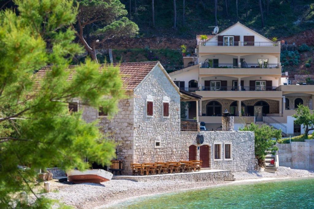 a large house on the shore of a body of water at Apartments Serzane in Zastražišće