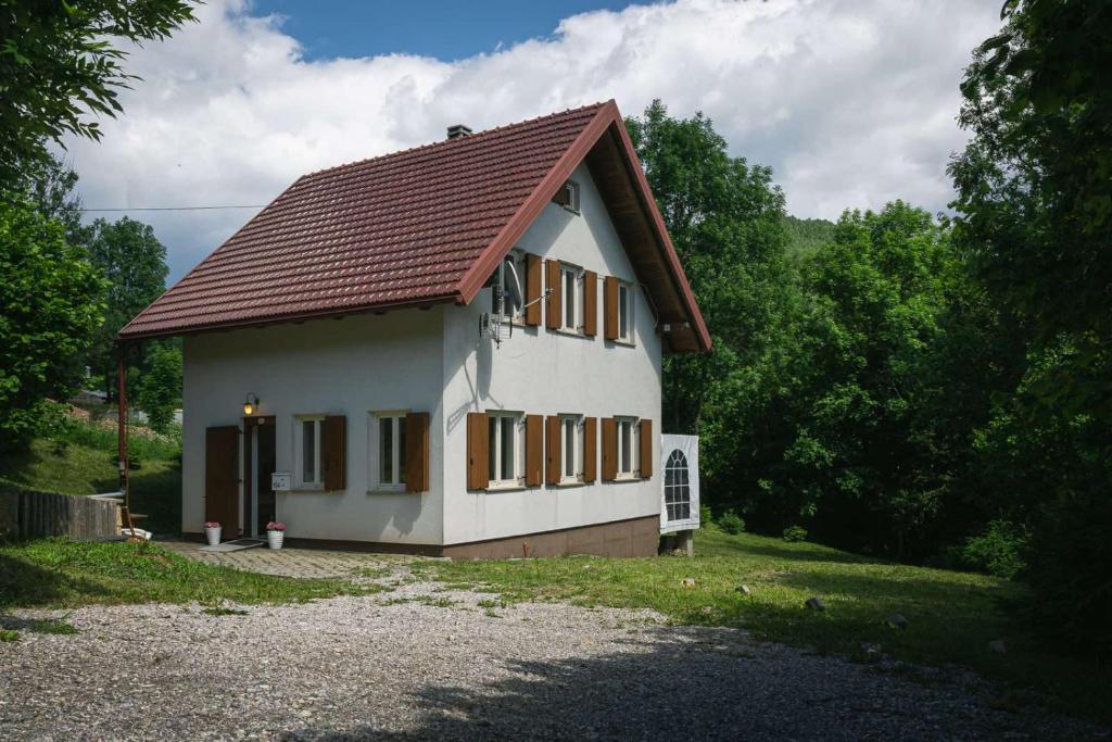a small white house with a brown roof at Kuća za odmor La Vi in Mrkopalj
