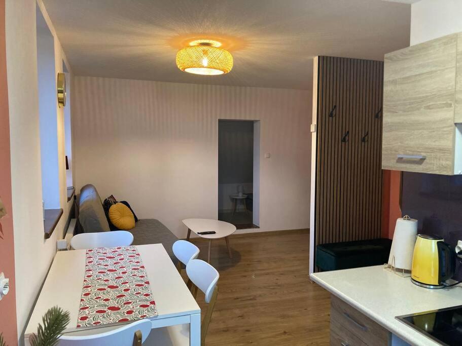 eine Küche und ein Wohnzimmer mit einem Tisch und Stühlen in der Unterkunft Top Apartment in Bielsko-Biała