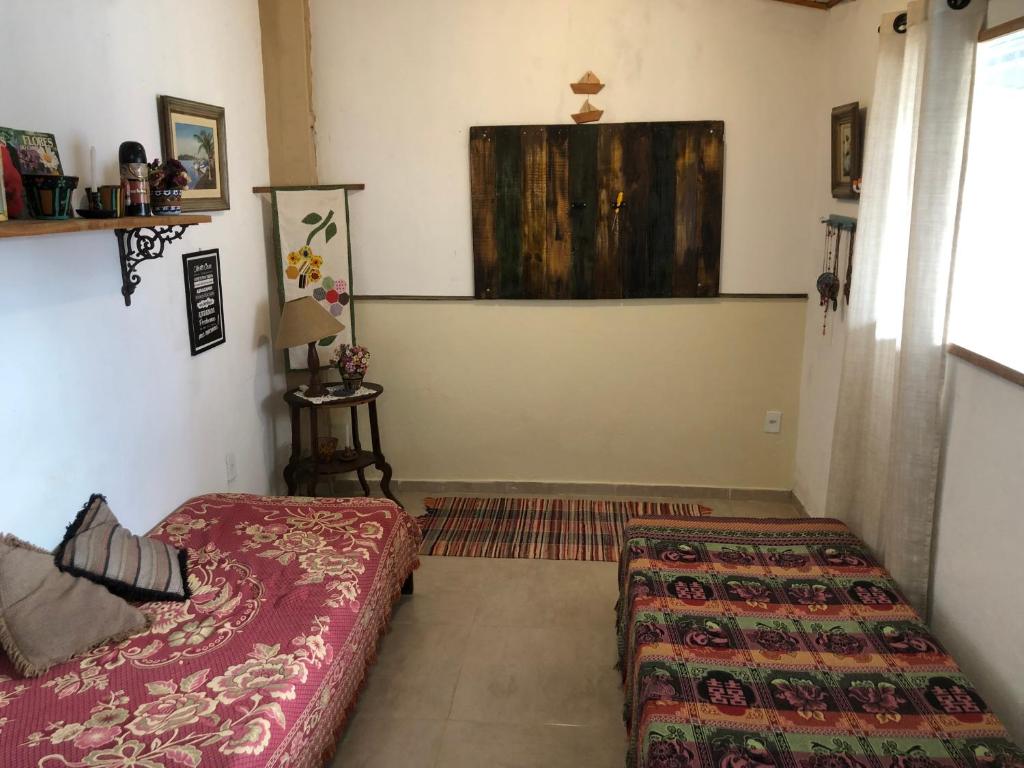 リオ・ダス・オストラスにあるCasa no Parque das Floresのベッドが2つと窓がある小さな部屋
