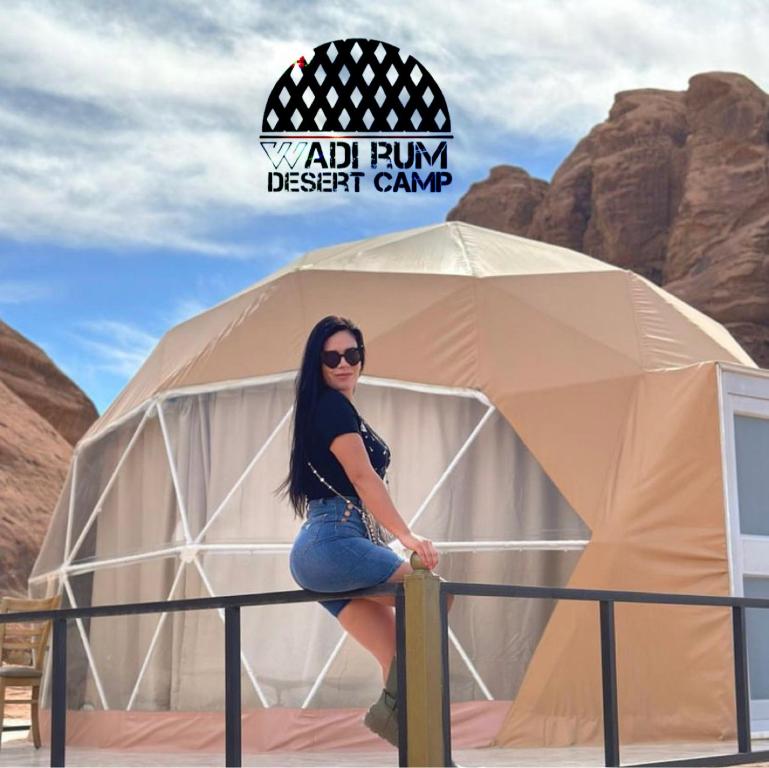 a woman sitting in front of a yoda trump desert camp at Wadi Rum desert camp in Wadi Rum