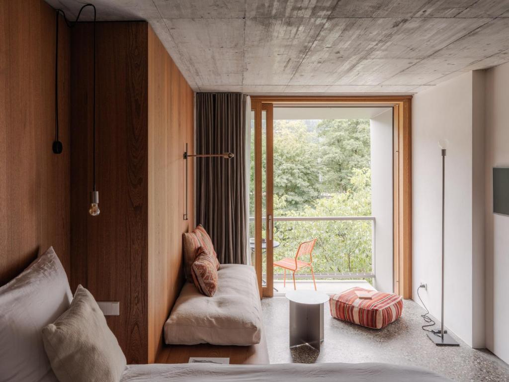 a bedroom with a bed and a large window at ArtBau Designhotel in Waldkirch