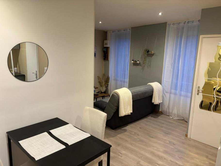 - un salon avec une table et un miroir dans l'établissement Le studio dijonnais, à Dijon
