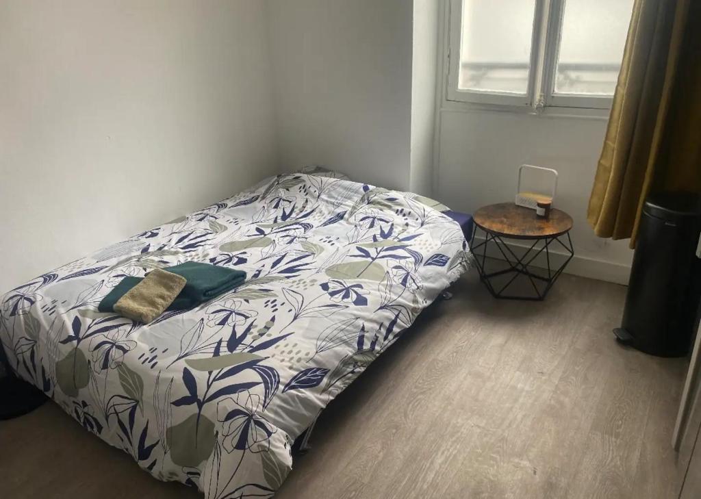 a bed sitting in a bedroom with a bedspread on it at Studio Vincennes centre in Vincennes