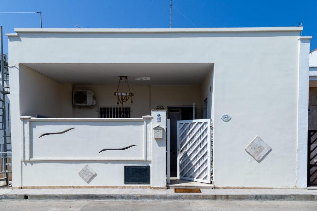 een wit gebouw met een poort en een deur bij YSOR CASA VACANZE in Casalabate