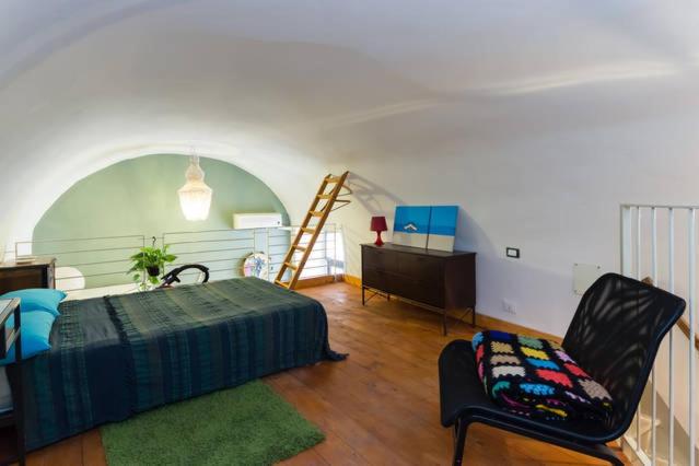 1 dormitorio con cama, silla y escritorio en Il Pozzo di Santa Teresa, en Catania