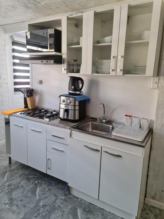 a kitchen with white cabinets and a sink at departamento in Puerto Montt