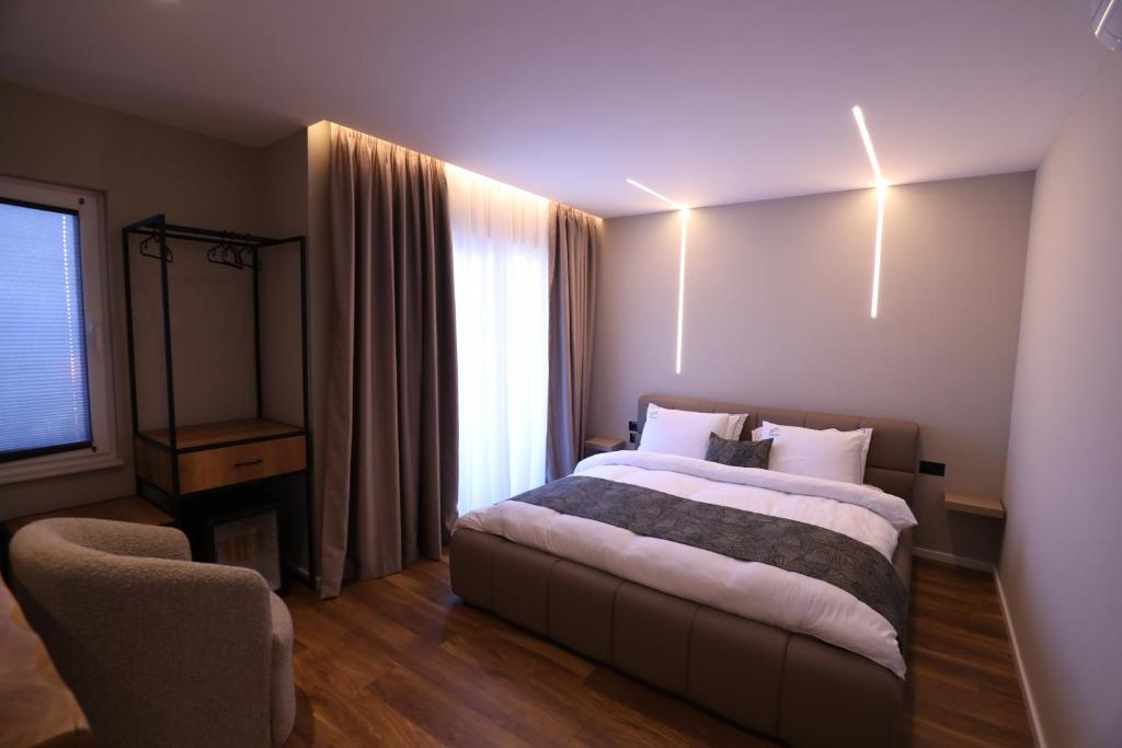 Dallga Suites في Tushemisht: غرفه فندقيه بسرير ونافذه