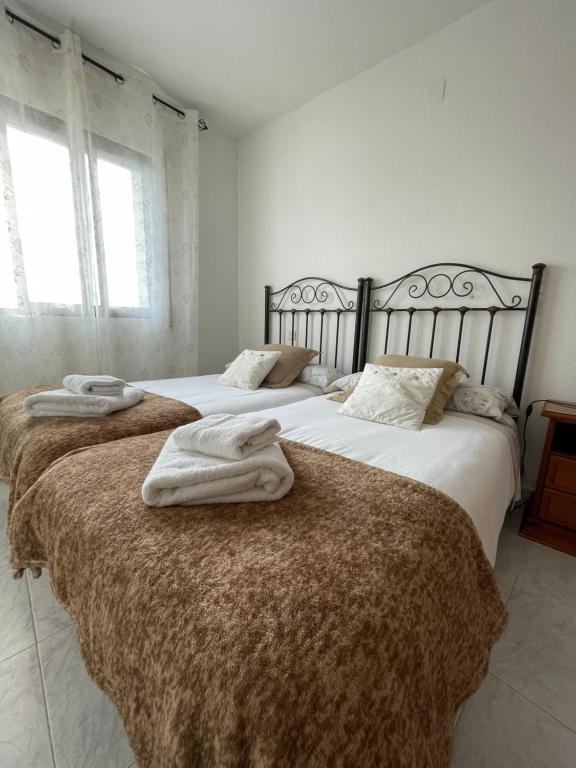 twee bedden in een slaapkamer met handdoeken erop bij APARTAMENTO PURI in Candeleda