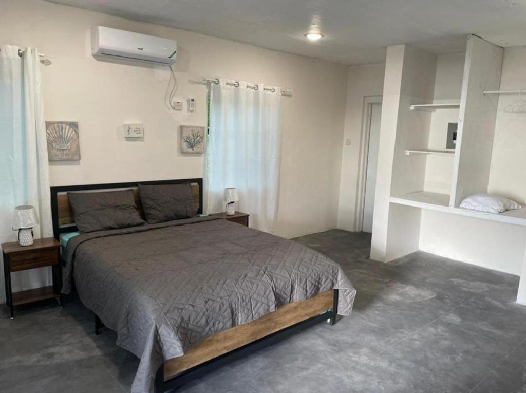 a bedroom with a large bed and a fan at Bri's On The Beach in Treasure Beach