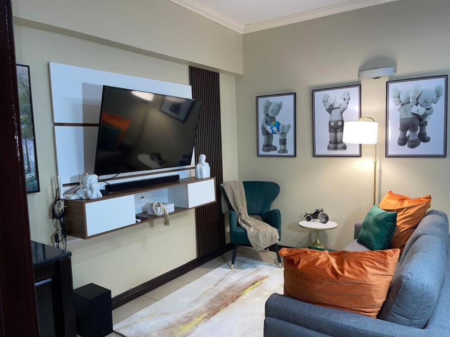 ein Wohnzimmer mit einem TV und einem blauen Sofa in der Unterkunft EliteStay at Casa De Barron in Kingston