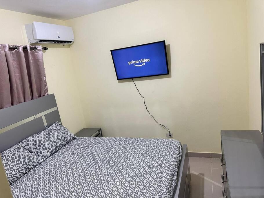 a bedroom with a bed and a tv on the wall at STD norte Apartamento Grande in Santo Domingo