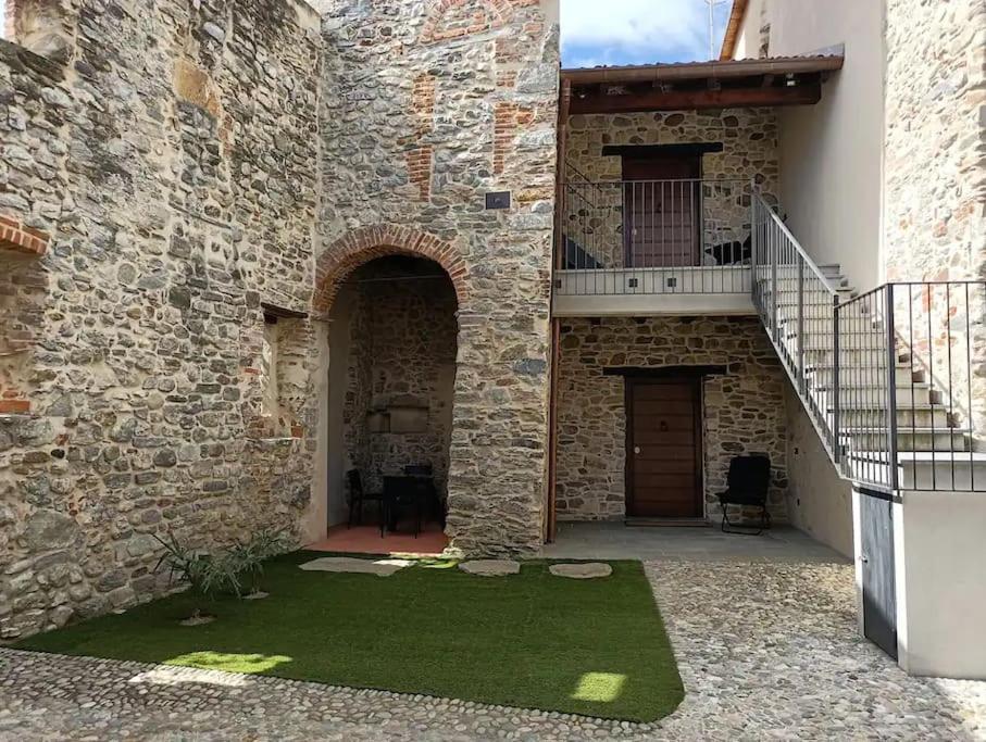 un edificio de piedra con escalera y patio en [Medioevo con giardino] Lake Varese wifi Netflix, en Gavirate