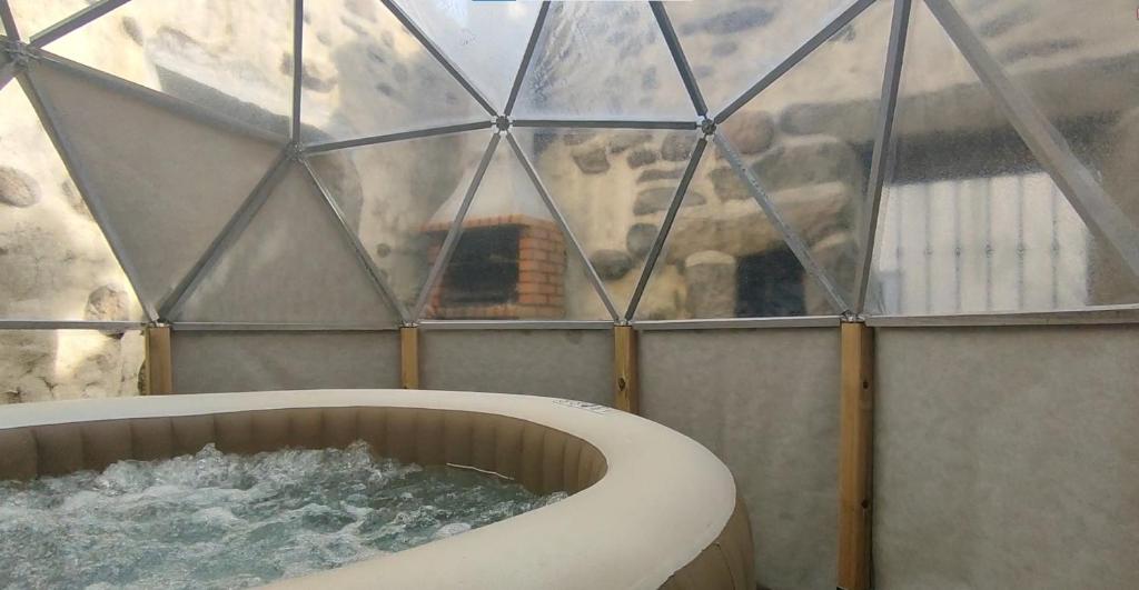 - une baignoire dans un igloo en verre avec de l'eau dans l'établissement Segredos da Montanha - Mangualde, à Mangualde