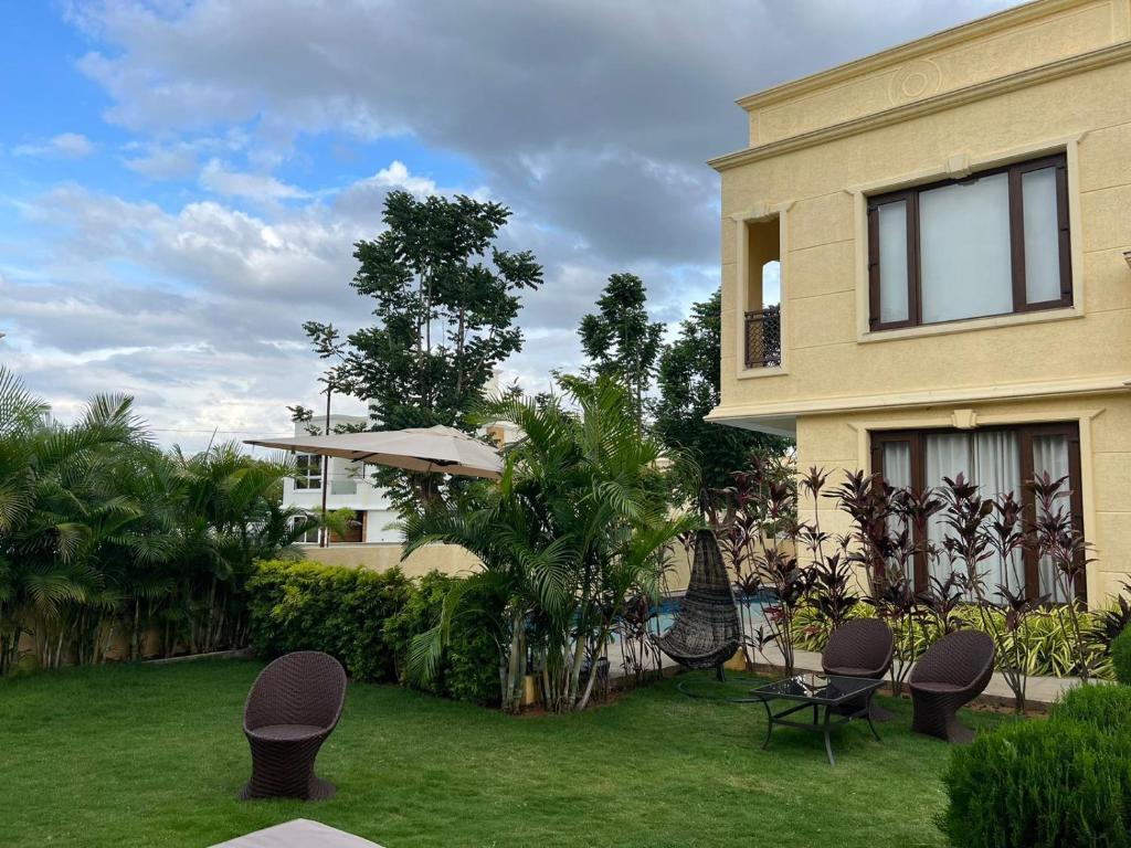 a house with a yard with chairs and a lawn sidx sidx sidx at Villa Vista - with Pool & Jaccuzi in Kundakal