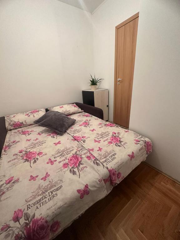 a bedroom with a bed with pink flowers on it at Apartman Edita in Sarajevo