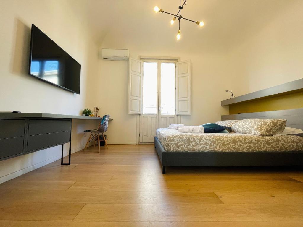 a bedroom with a bed and a flat screen tv at Dimora del Mercante in Catania