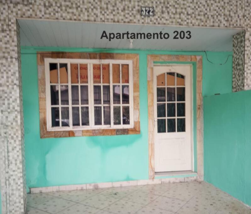 un edificio azul con puerta y ventana en Apartamento em Muriqui/RJ - apt 203, en Mangaratiba