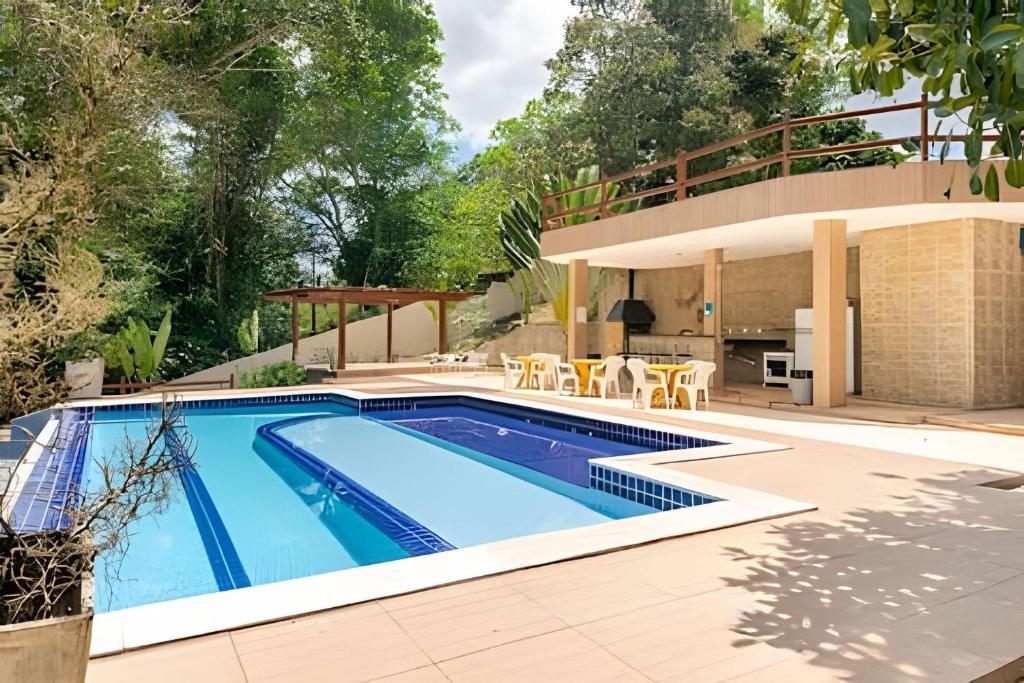 a swimming pool in a backyard with a house at Sítio em Aldeia com piscina e lago in Camaragibe