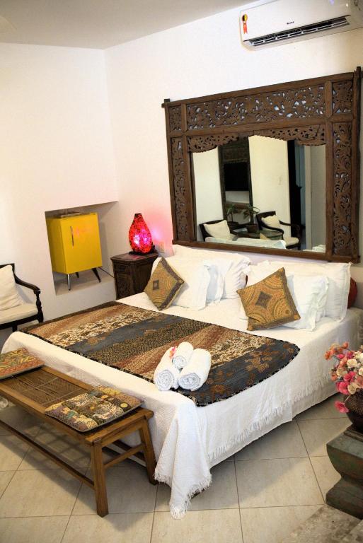 a bedroom with a large bed with a large mirror at Casa Petunia Pousada Boutique in Salvador