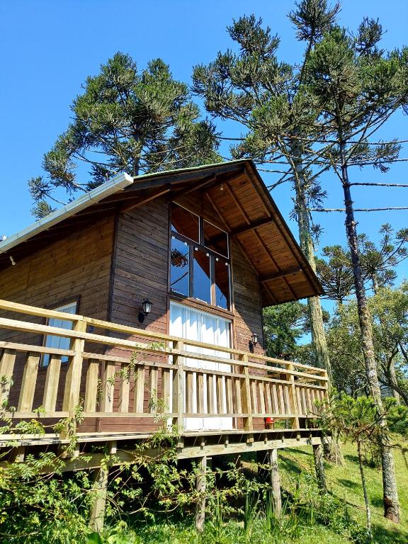 a cabin in the woods with a wrap around deck at Pousada Recanto das Araucárias in Urubici