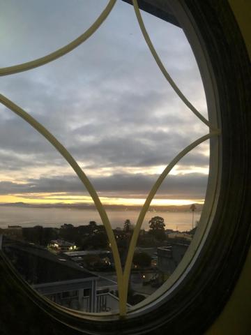a window with a view of a city and the ocean at Margaret's Penthouse at Cannery Row and Aquarium in Monterey