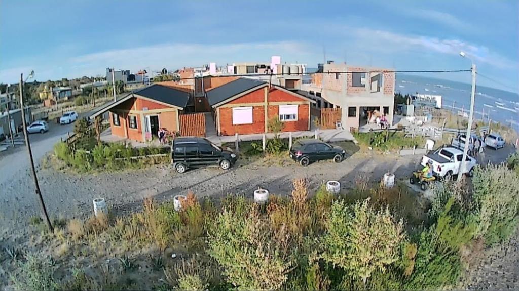a house with cars parked in a parking lot at Complejo Soliera in Playa Unión