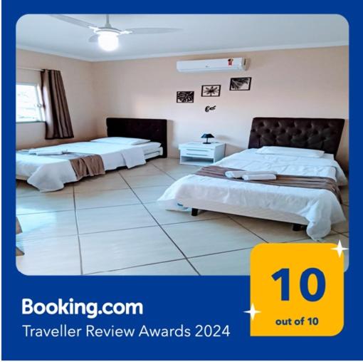 a hotel room with two beds in a room at Casa Confortável, 3 Quartos, Ar Condic. 300 Mega, Taubaté in Taubaté