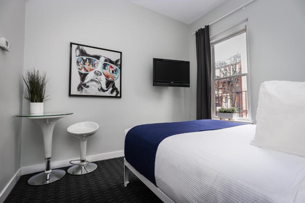 a hotel room with a bed and a window at Cozy Studio on Newbury Street, #1 in Boston