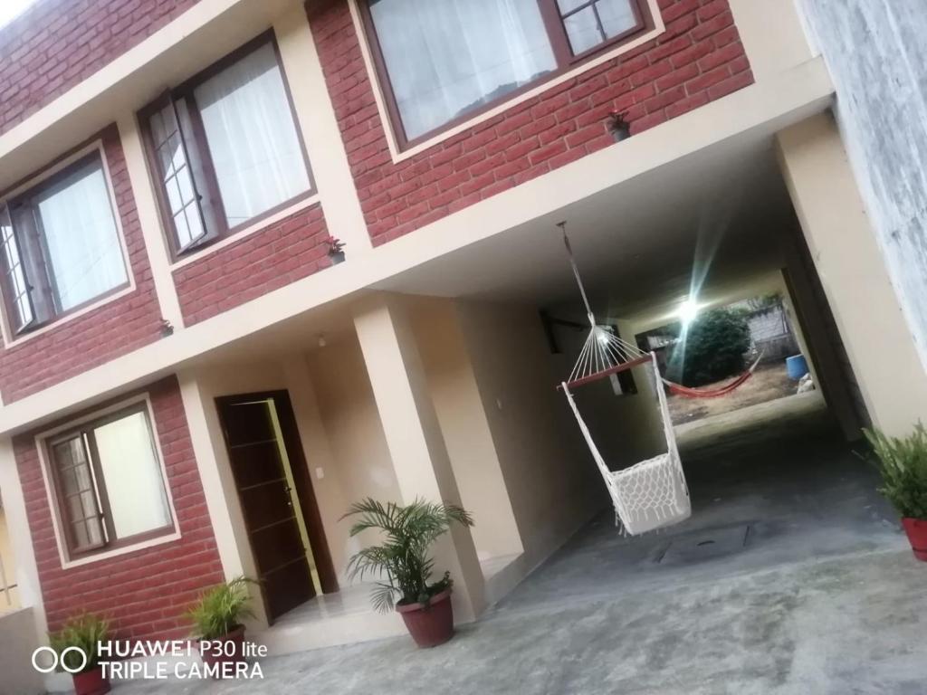 une maison avec un hamac suspendu dans la cour dans l'établissement CASA DE LINDA, à Baños