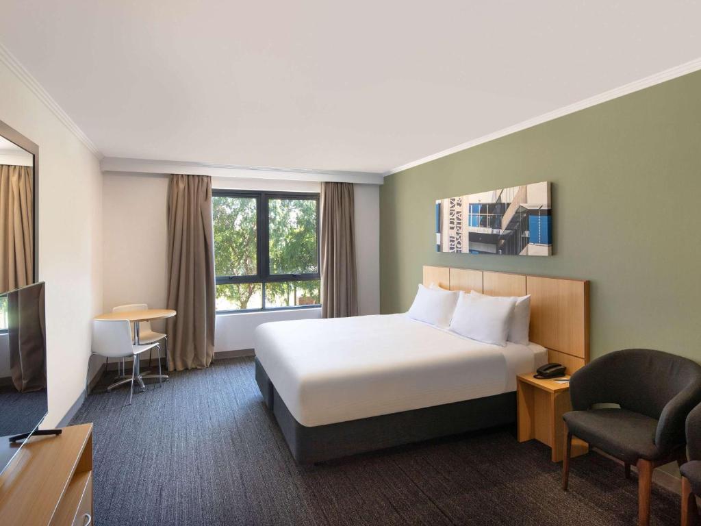 悉尼Mercure Sydney Macquarie Park的配有床和电视的酒店房间