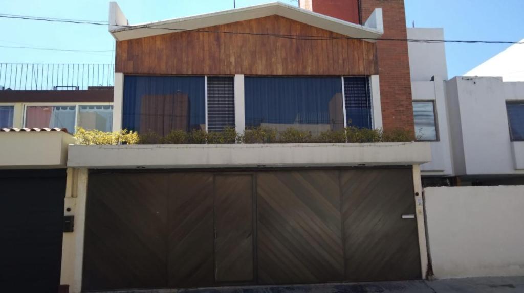 une maison avec un balcon au-dessus d'un garage dans l'établissement Habitación amplia en casa grande y sola en Coapa, junto al Club America, cerca de Miramontes, Tlalpan, Periférico, à Mexico