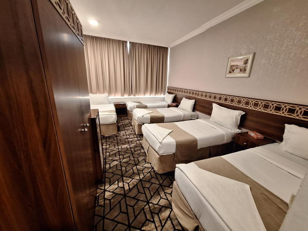 Ajyad的住宿－فندق لؤلؤة الصفا，酒店客房,设有三张床和一张沙发