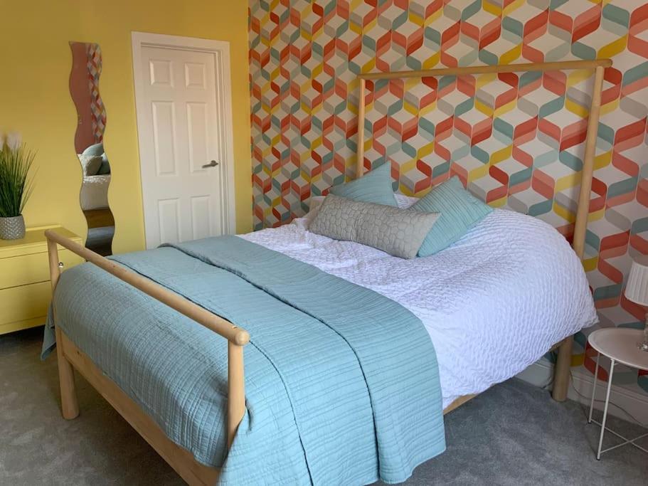 a bedroom with a bed with a wooden head board at Family friendly flat, Perfect for a Dorset escape in Bournemouth