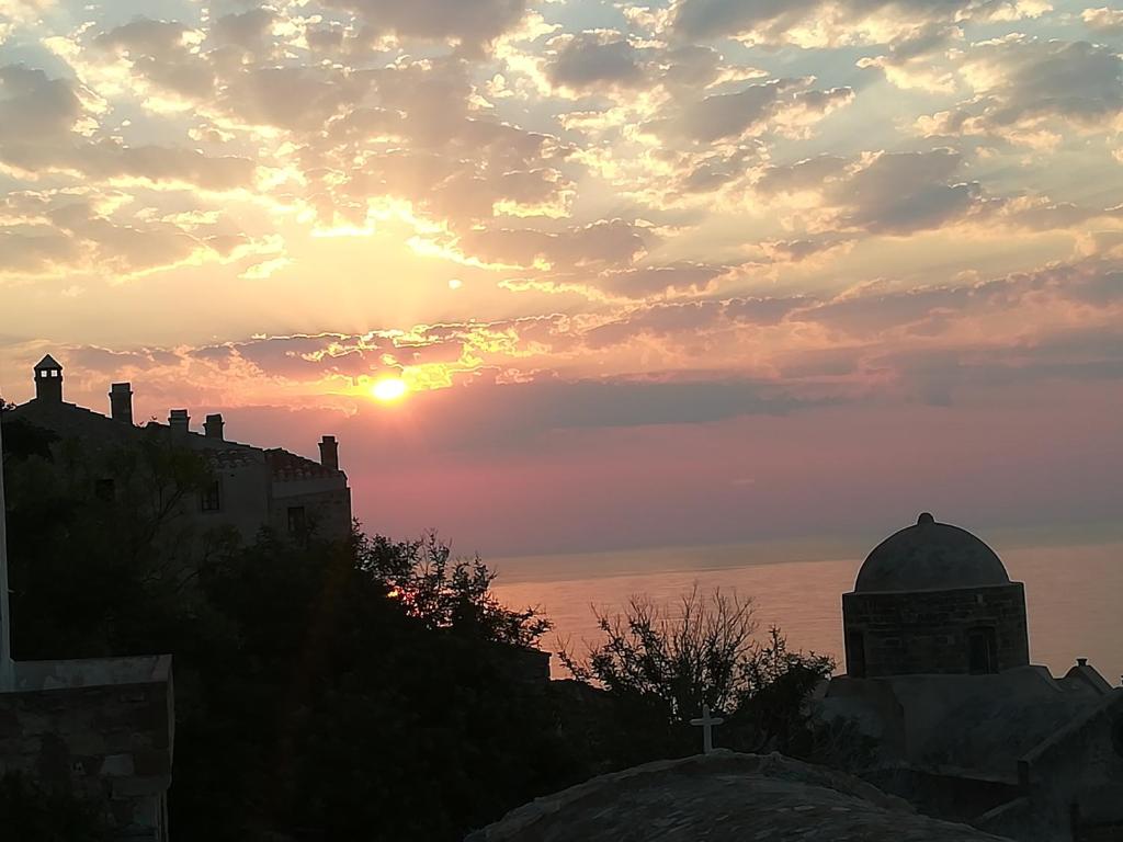 a sunset over the ocean with a building and a mosque at Kissamitakis Guesthouse in Monemvasia