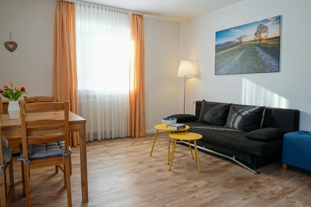 a living room with a couch and a table at HoFer am Zeitberg Ferienwohnung Ammertal in Bad Kohlgrub