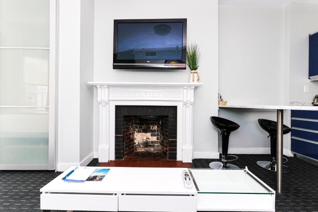 een woonkamer met een open haard en een tv op een mantel bij Furnished Newbury Street Studio, #6 in Boston