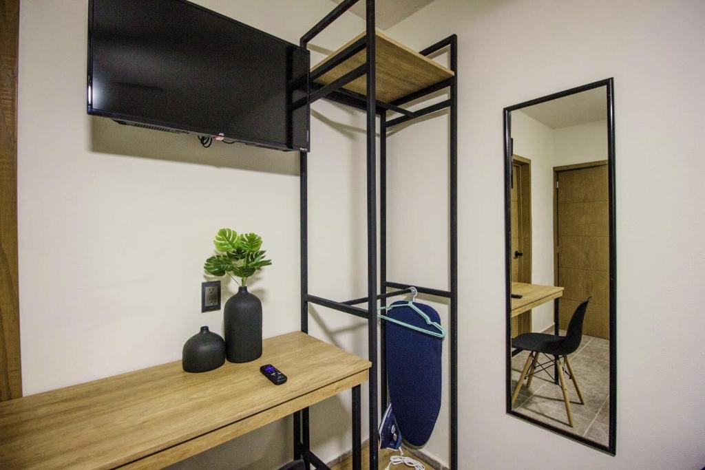 a room with a desk with a mirror and a tv at LOFT ALATORRE in Guadalajara