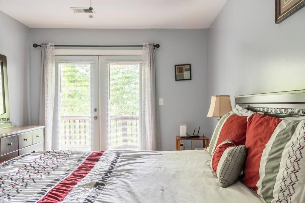 ein Schlafzimmer mit einem Bett und einem großen Fenster in der Unterkunft Private room balcony and bathroom in Charleston in Charleston