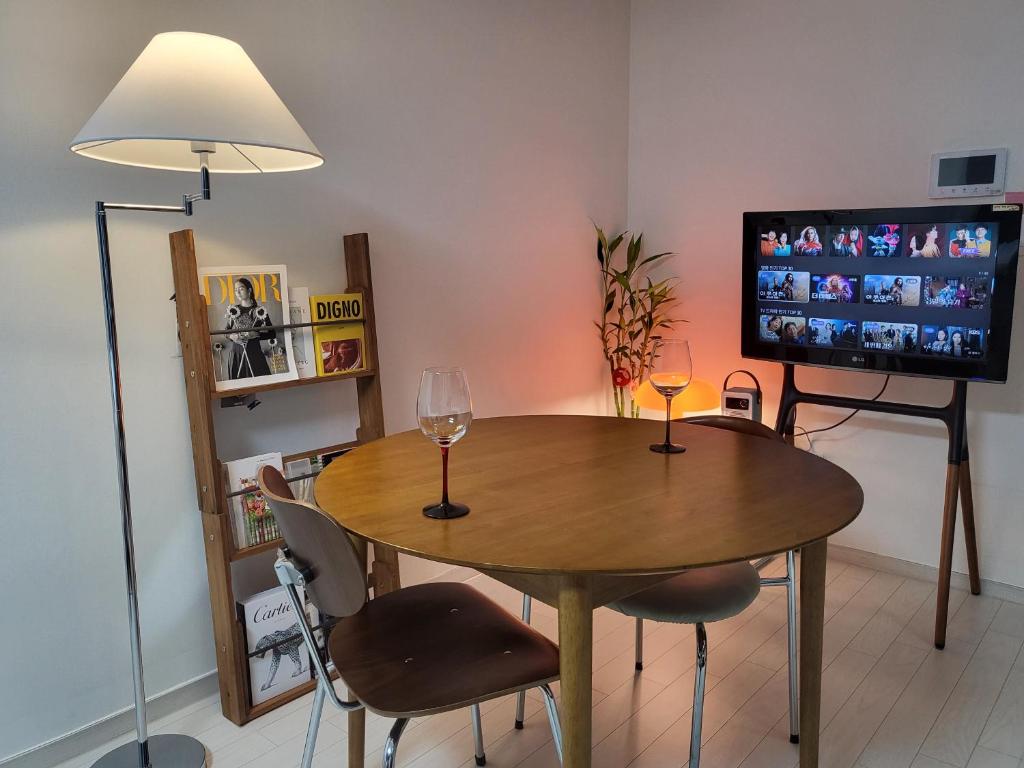 a dining room with a table and two wine glasses at feel at home in Daegu