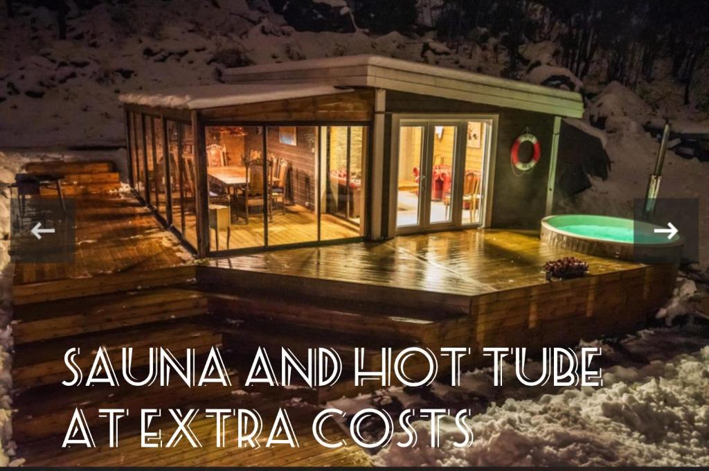 a house with a hot tub on a deck at Sea view Holmestrand sauna and hot tube appartment in Holmestrand