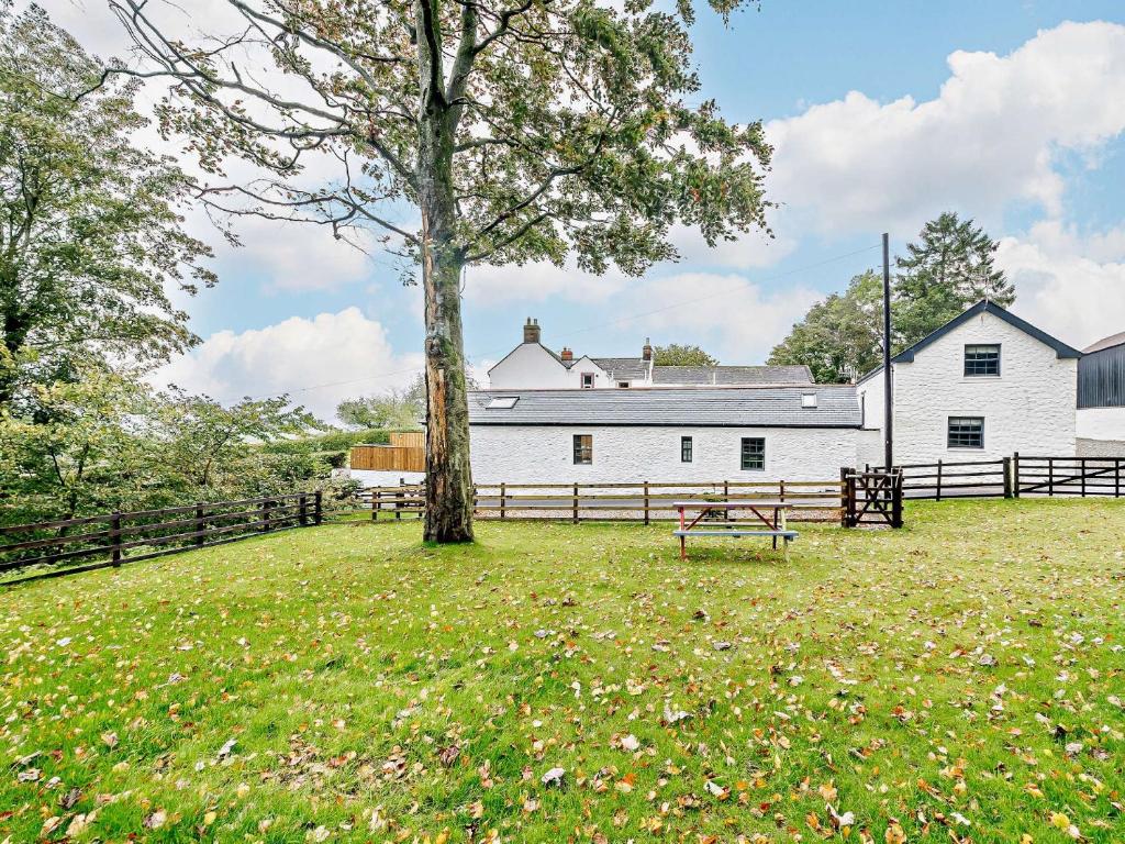 uma árvore num campo com um edifício branco em 1 Bed in Lockerbie 93110 em Lockerbie