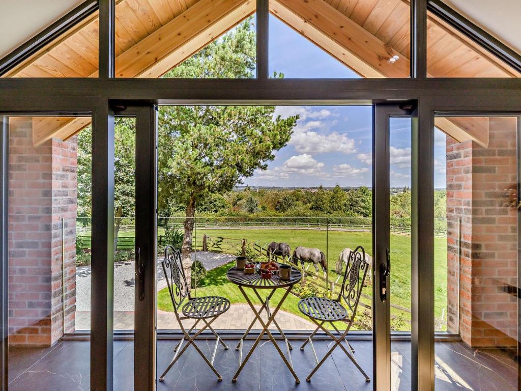 un patio con mesa y sillas y vistas a un campo en 1 Bed in Melton Mowbray 93068 