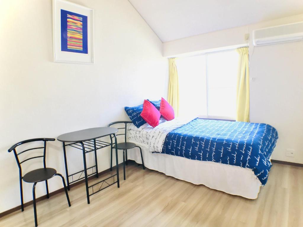 1 dormitorio con 1 cama, mesa y sillas en Best Room In Kawagoe 3, en Kawagoe