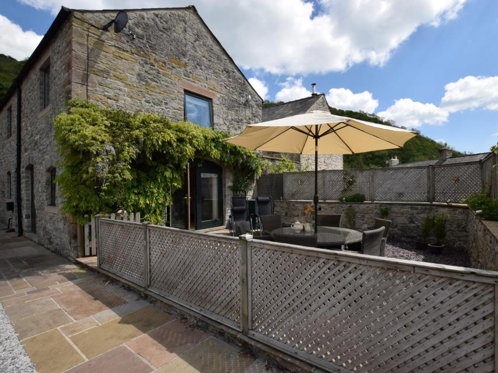 an outdoor deck with an umbrella and a building at 3 bed in Cressbrook 57037 in Cressbrook