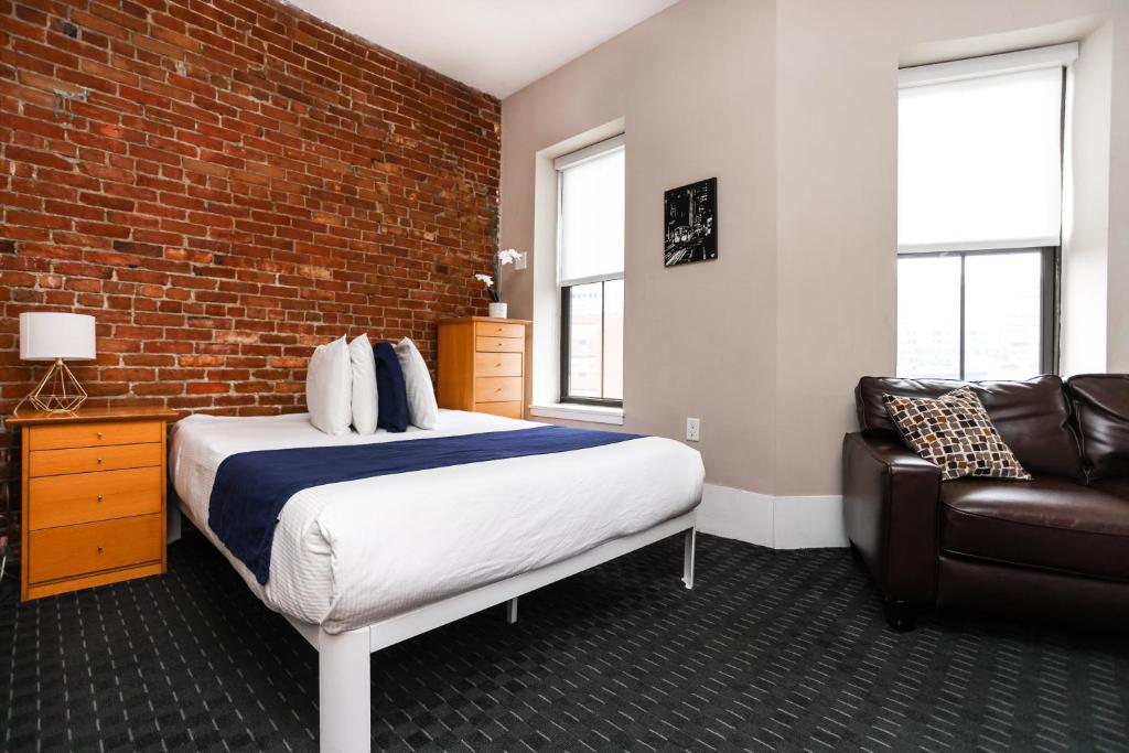 een slaapkamer met een bed en een bakstenen muur bij Stylish Studio in Boston Brownstone, C.Ave #21 in Boston