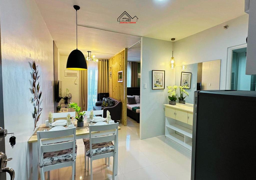 a kitchen and living room with a table and chairs at Palawan 1BR Summer Get-away Deluxe with Balcony FREE Pool and Gym - T2 6 Diamond in Puerto Princesa City