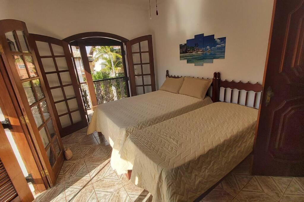 a bedroom with two beds and an open door at Castelinho do Felix Guarujá Pernambuco in Guarujá