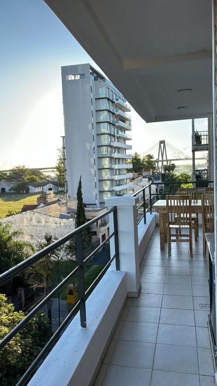 un balcone con tavolo e sedie e un edificio di Departamento Il Piamonte a Corrientes
